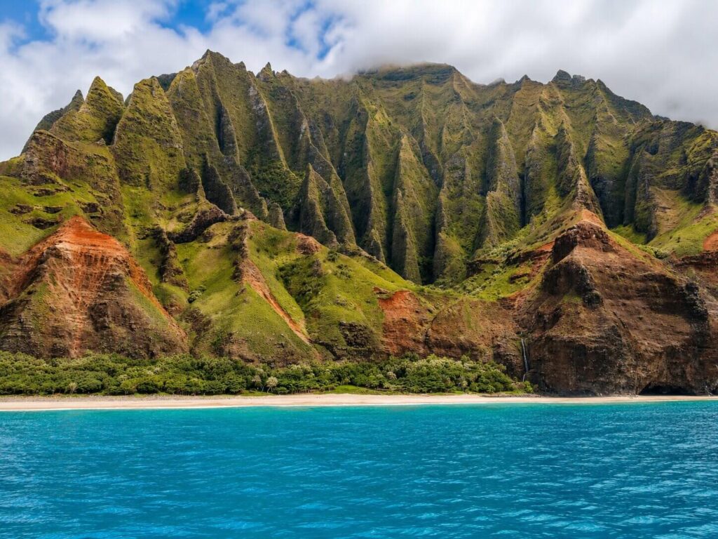 Dramatic green cliffs of the Na Pali Coast rising above the ocean on Kauai, the Garden Isle