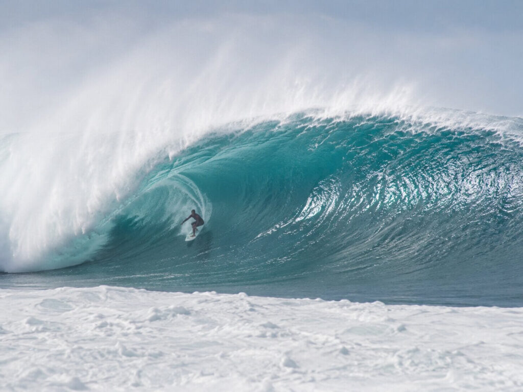 Surfer riding a large barrel wave on Oahu's North Shore