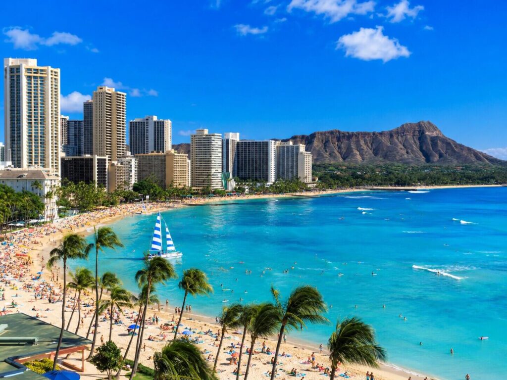 Waikiki Beach lined with palm trees and hotels beneath Diamond Head
